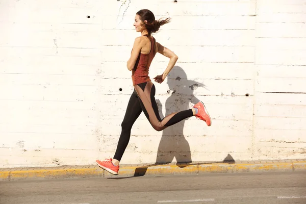 健康的年轻女子在城市户外奔跑的全身侧面肖像 — 图库照片