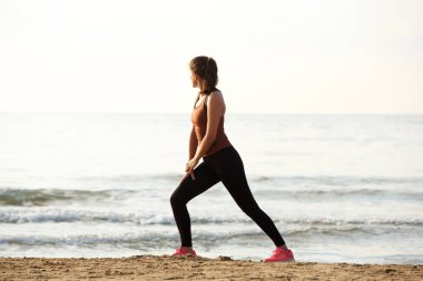 Kas germe egzersiz yaptıktan sonra kumsalda güzel jogger tam uzunlukta portresi