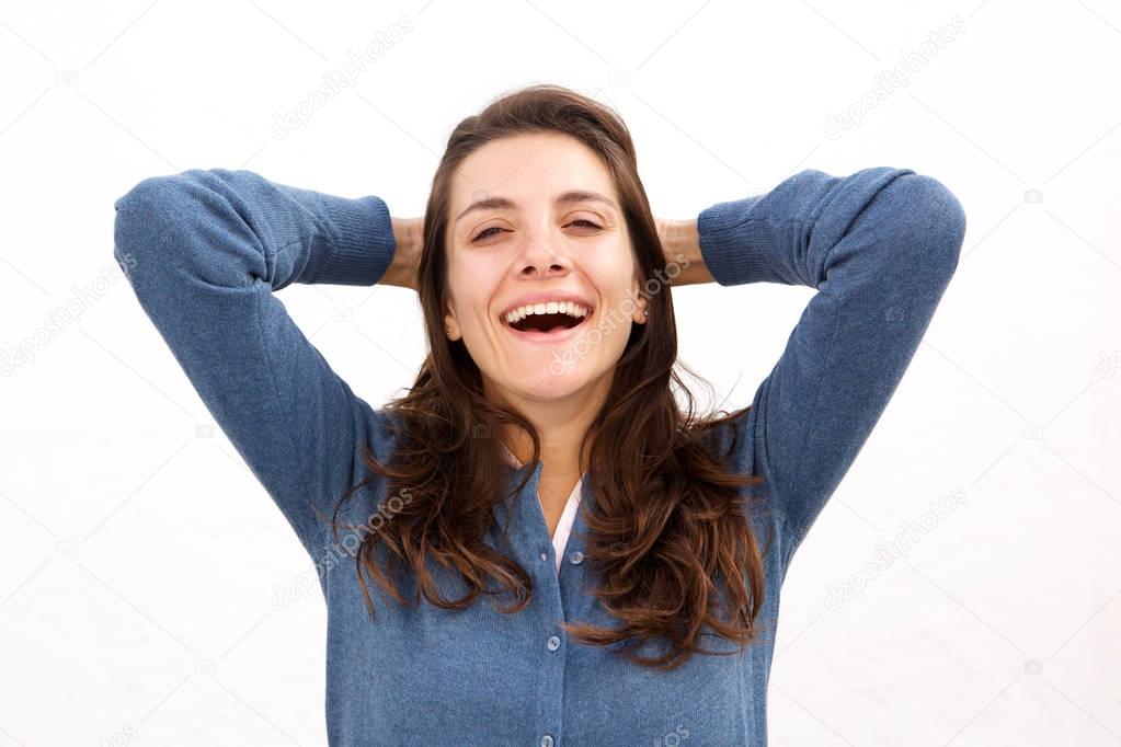 Close up portrait of laughing woman standing with hands in hair by white background