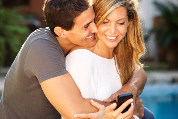 Close Portrait Smiling Couple Sitting Embrace Looking Smart Phone — Stock Photo, Image