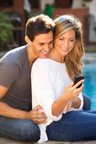 Retrato Casal Feliz Sentado Piscina Olhando Para Telefone Inteligente — Fotografia de Stock