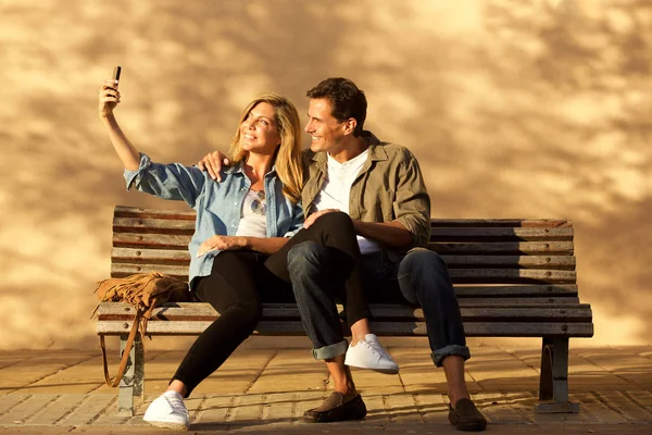 Volledige Lengte Portret Van Gelukkige Paar Zitten Bankje Selfie Nemen — Stockfoto