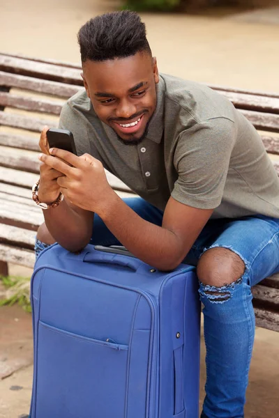 Cep Telefonu Bavul Ile Oturan Genç Afro Amerikan Adam Portresi — Stok fotoğraf