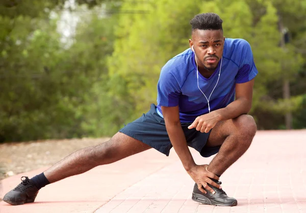 Porträtt Fit Unga Afroamerikanska Man Gör Stretching Övning Medan Lyssnar — Stockfoto