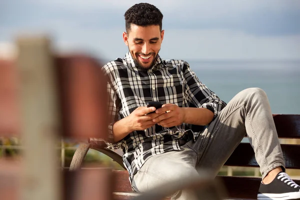 携帯電話でテキスト メッセージを送信する幸せな若いアラビア語男の肖像 — ストック写真