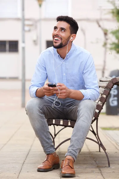 Hareket Eden Telefon Kulaklık Ile Bankta Oturan Genç Arapça Adam — Stok fotoğraf