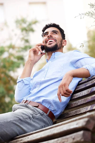 クールな若いアラビア語男笑顔と携帯電話で話しているの肖像画 — ストック写真