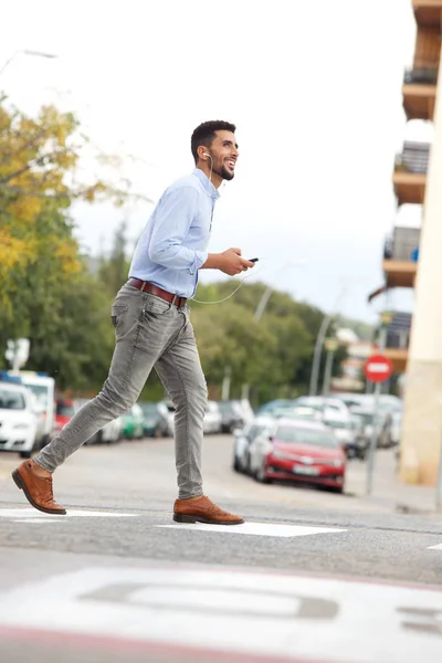 Retrato Corpo Inteiro Jovem Árabe Andando Rua Com Celular Ouvindo — Fotografia de Stock