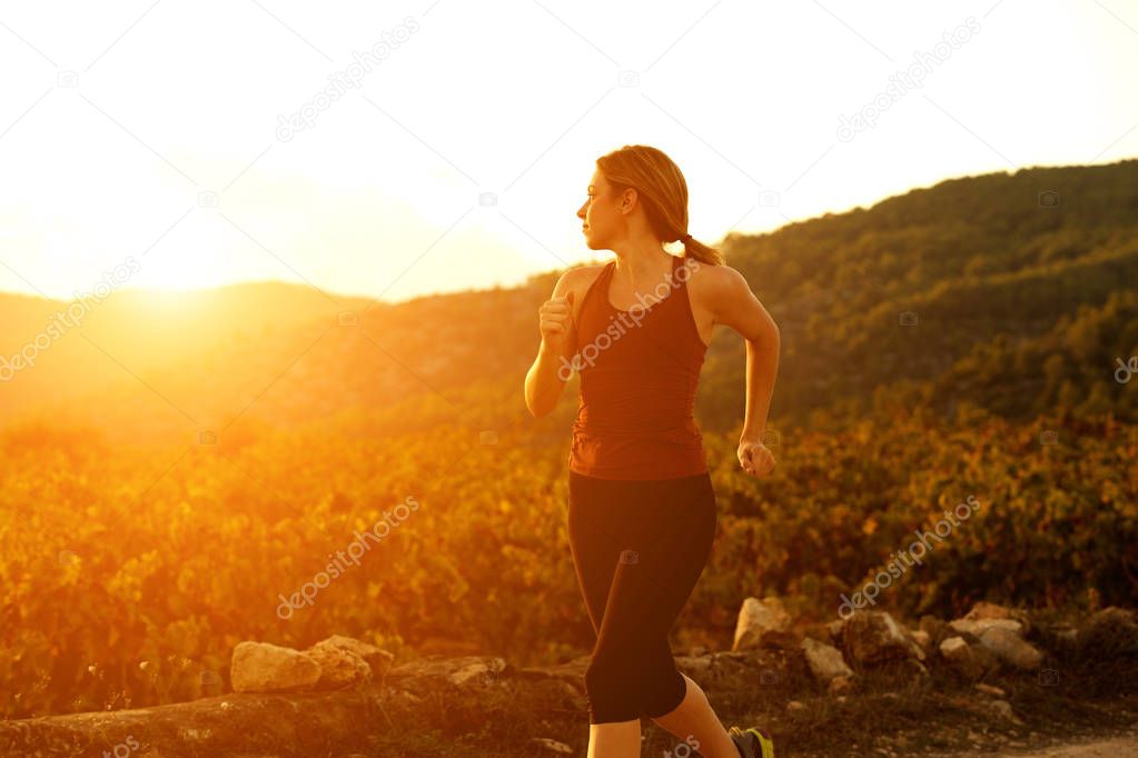 Portrait of healthy young woman jogging outdoors in nature