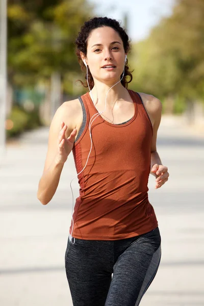 Portrait of healthy young woman jogging outdoors