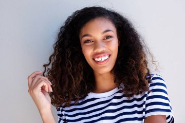 Beyaz arka plan üzerinde gülümseyen çekici genç Afro-Amerikan kadın portresi kapatın