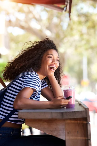 Retrato Lateral Una Joven Afroamericana Riendo Con Smartphone Cafetería — Foto de Stock