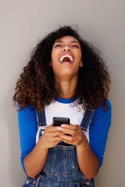Retrato Una Hermosa Joven Afroamericana Riendo Con Smartphone Sobre Fondo — Foto de Stock