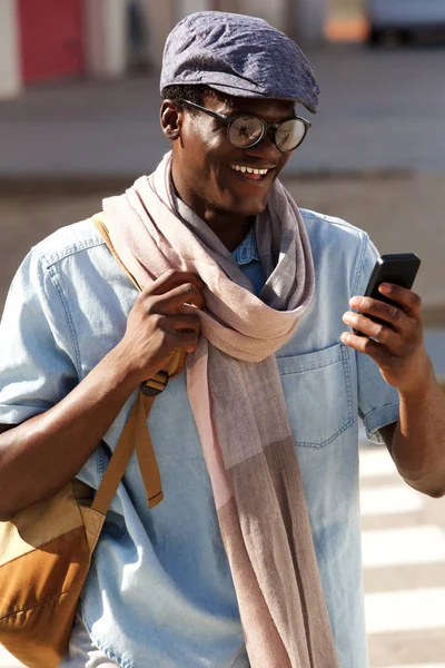 Porträtt Glad Ung Man Med Glasögon Och Cap Tittar Mobiltelefon — Stockfoto