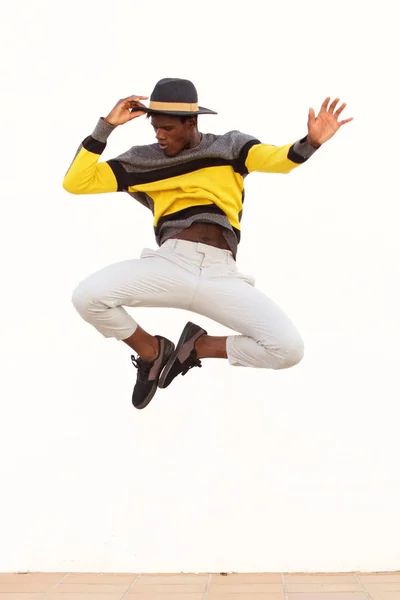 スタイリッシュな若い男性ダンサー ジャンプと白い背景の上に彼の動きを示すの肖像画 — ストック写真
