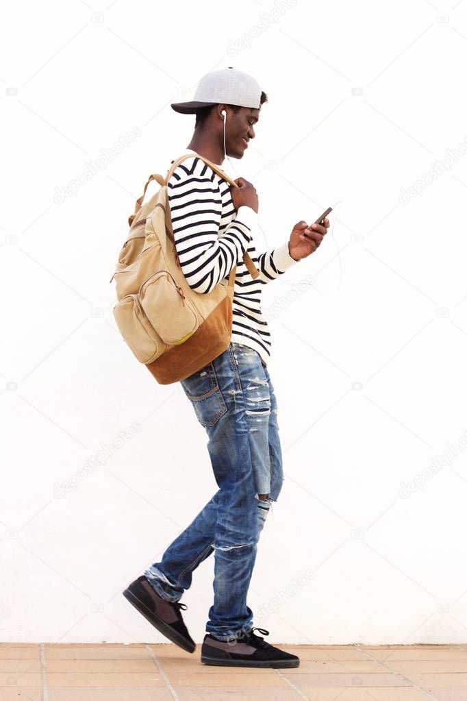 Full length side portrait of African American student walking with smart phone