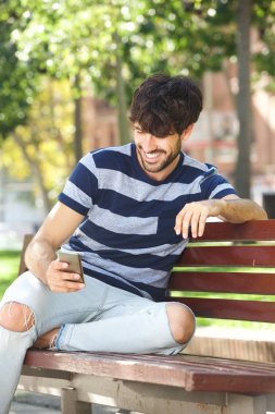 Cep telefonu Park ile gülümseyen genç adam portresi