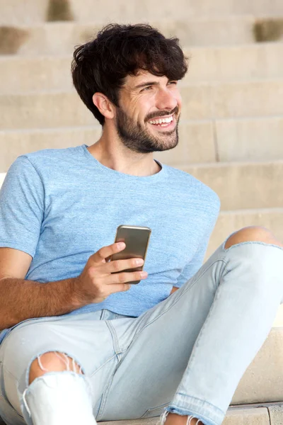 英俊的年轻人坐在智能手机的肖像 — 图库照片