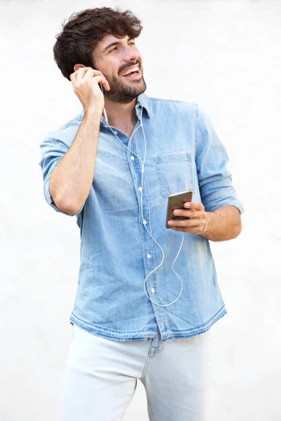 Portrait of cool guy listening to music with smartphone and earphones