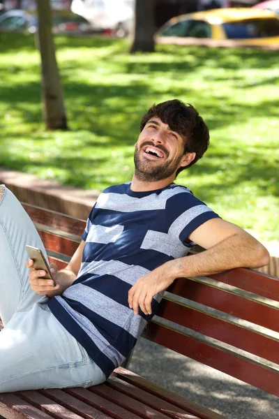 Portret Van Gelukkig Man Zittend Bankje Park Met Mobiele Telefoon — Stockfoto