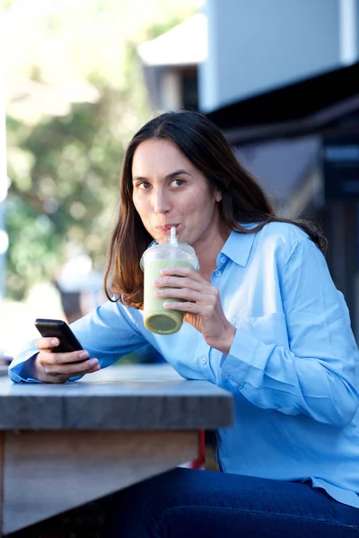 Portret Van Vrouw Drinken Sap Buiten Met Mobiele Telefoon Hand — Stockfoto
