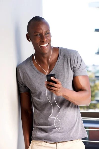 Портрет Крутого Африканского Американца Прислонившегося Стене Слушающего Музыку Мобильного Телефона — стоковое фото