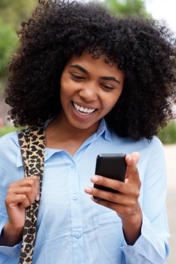 Neşeli genç Afro-Amerikan kadın dışında akıllı telefon ile portresi kapatın
