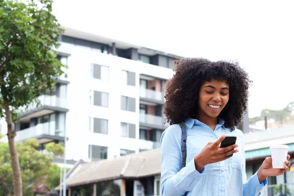 都市の外で携帯電話と歩いているアフリカ系アメリカ人の少女の肖像画 — ストック写真