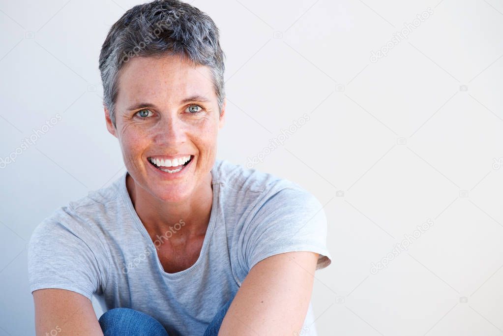 Close up portrait of beautiful older woman smiling against white wall