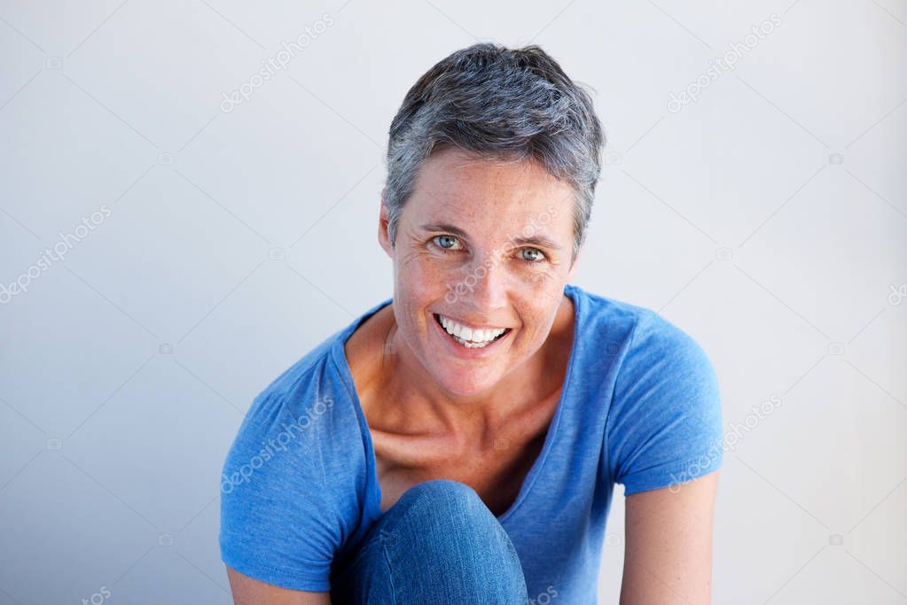 Close up portrait of beautiful mature woman smiling against white background