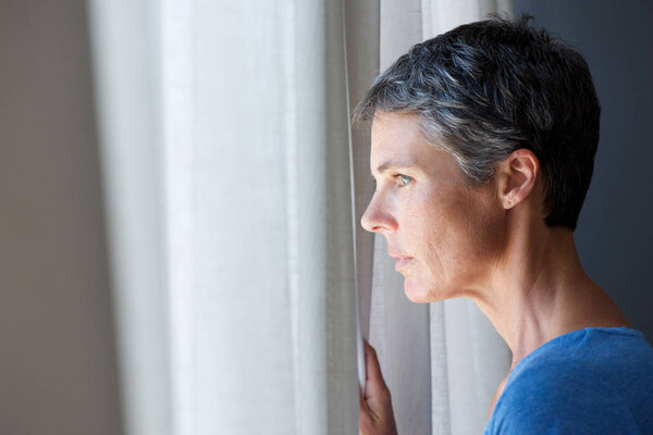 Portrait of older woman looking out window