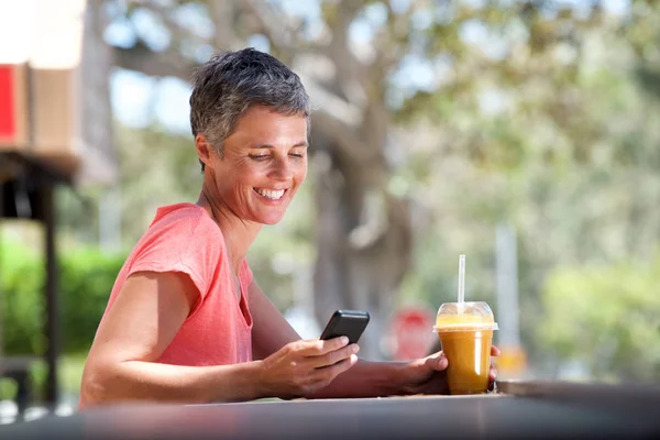 Retrato Mujer Mediana Edad Sonriente Sentada Afuera Con Teléfono Móvil — Foto de Stock