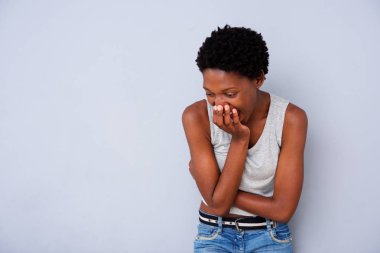 Ağız gri arka plan üzerinde kapsayan el ile gülüyor neşeli genç Afro-Amerikan kadın portresi