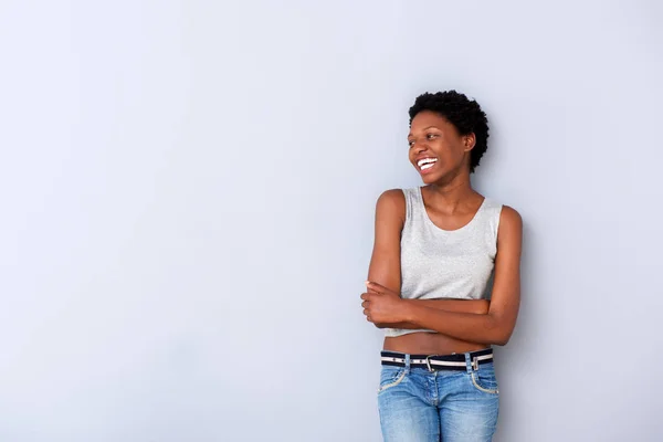欢快的年轻非洲裔美国妇女的肖像笑着用双臂越过灰色墙 — 图库照片