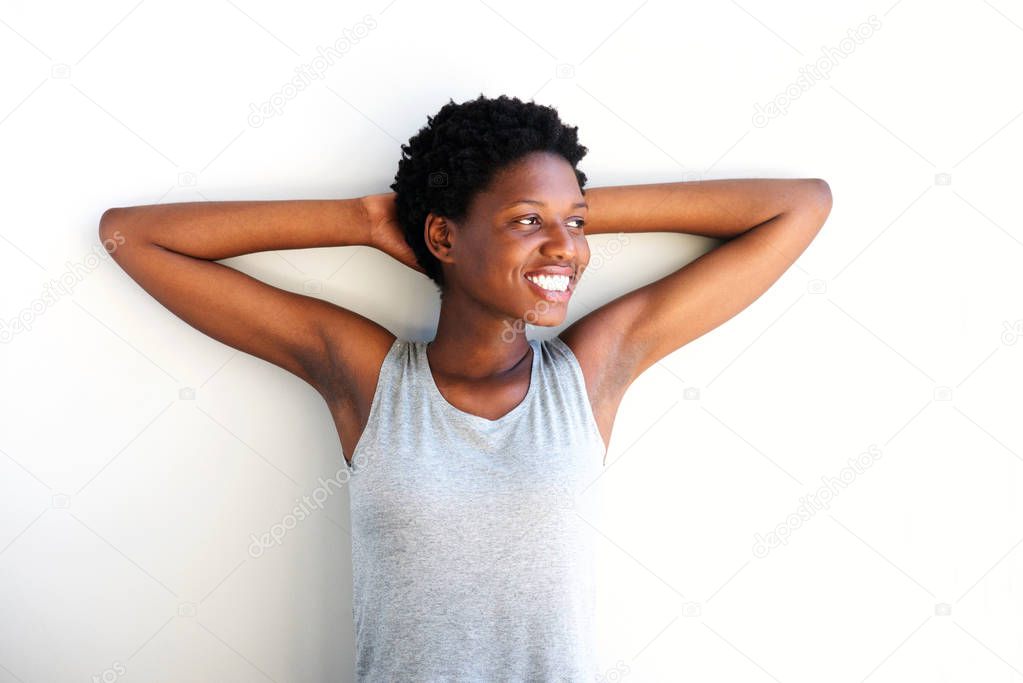 Portrait of relaxed african woman with hands behind head and looking away on white background