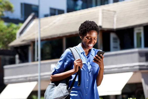 微笑的年轻女学生的肖像在户外散步 在智能手机上阅读短信 — 图库照片