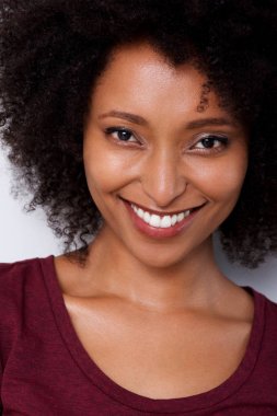 Gülümseyen kıvırcık saçlı genç Afro-Amerikan kadın portresi kapatın