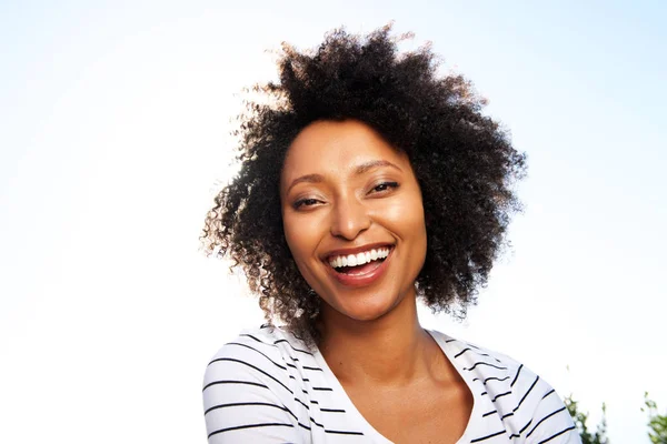 明るい太陽の光に対して屋外笑ってうれしそうな若い黒人女性の肖像画を間近します — ストック写真