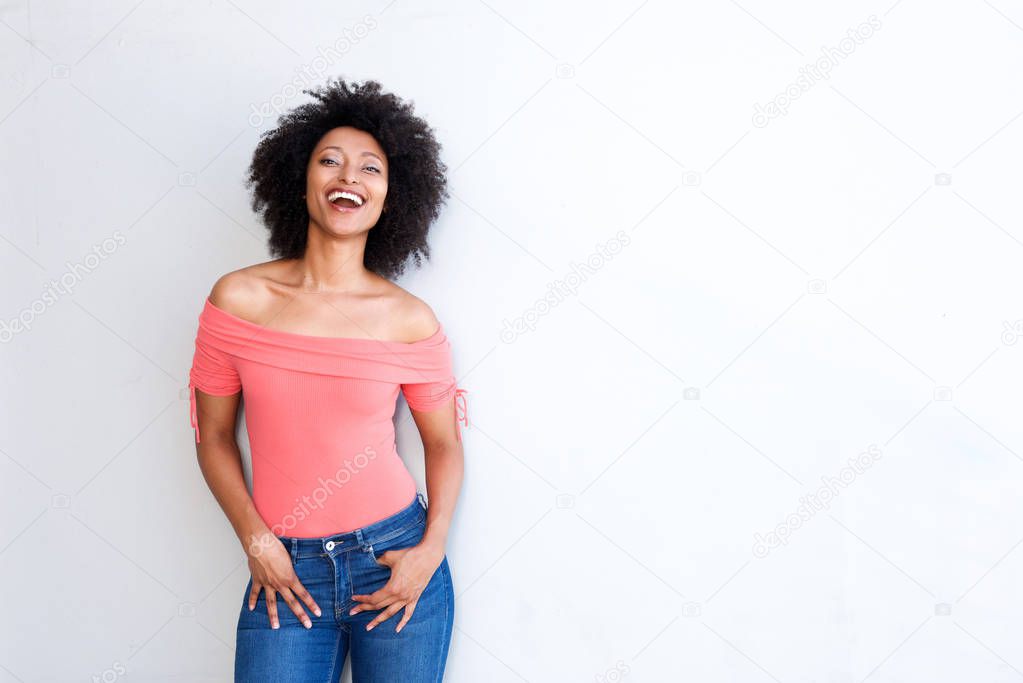 Portrait of confident young woman laughing against white background with copy space