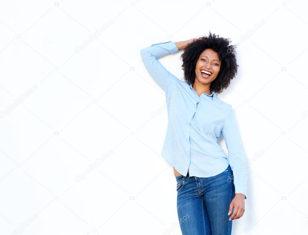 Portrait of young woman laughing with hand in hair on white background