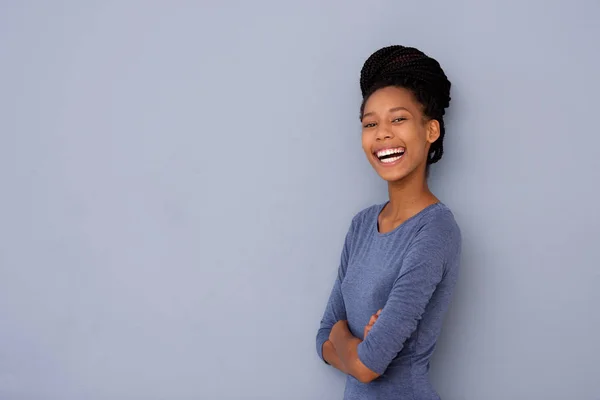 腕を交差 灰色の壁で笑って立っている陽気なアフリカ系アメリカ人の若い女性の肖像画 — ストック写真