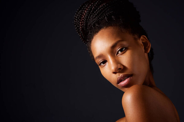 Close up portrait of pretty african woman with naked shoulders looking at camera