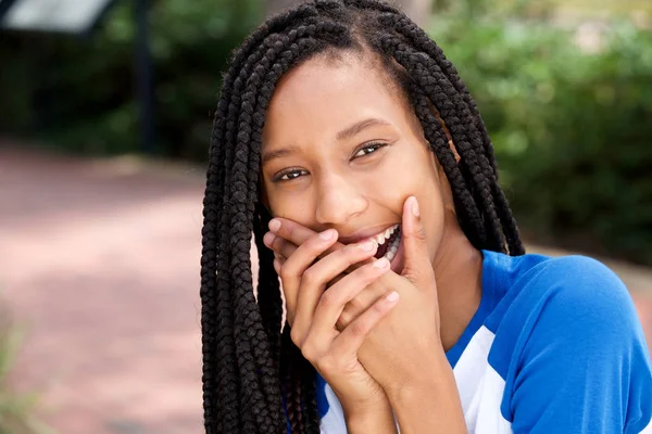口を覆っている手で笑ってかわいいアフリカ系アメリカ人女の子の肖像画を間近します — ストック写真