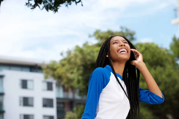 屋外で携帯電話で話している幸せな若いアフリカ系アメリカ人女の子の肖像画 — ストック写真