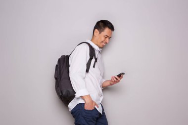 Yan çanta ve cep telefonu duvara yaslanmış olan rahat büyük adam portresi