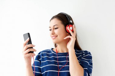 Hareket eden telefon ve kulaklık ile müzik dinlemek genç kadın portresi