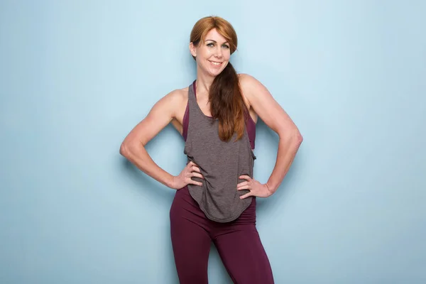 Portrait Muscular Mature Woman Standing Blue Wall Hands Hips — Stock Photo, Image