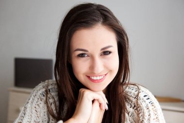 Ellerinde eğilerek gülümseyen kız portresi kapatın