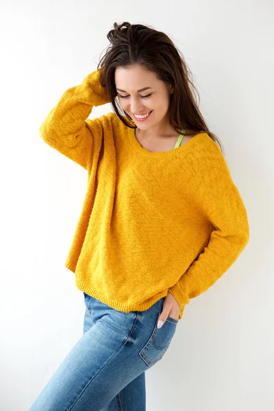白い壁に黄色いセーターの笑顔の美しい若い女性の肖像画 — ストック写真