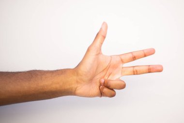 Beyaz arka planı işaret eden üç parmağıyla Afro-Amerikan erkek kolunu kapat.